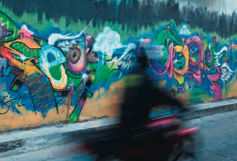 Panning con motociclista davanti a un murale